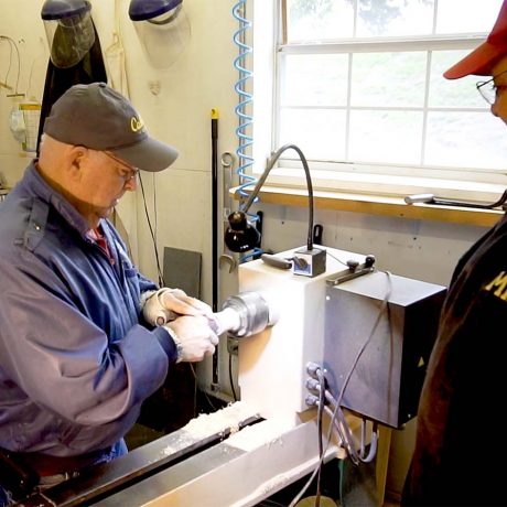 Two men using a machine for woodworking